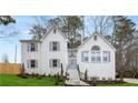 Charming two-story white brick home with symmetrical design, dormers, blue shutters, and a well-manicured lawn at 101 Saddlehorn Ct, Woodstock, GA 30188