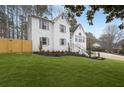 Beautifully landscaped yard surrounds this white brick two-story home, complete with manicured lawn and black mulch flower beds at 101 Saddlehorn Ct, Woodstock, GA 30188