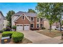 Beautiful two-story brick home with a well-manicured lawn and a two-car garage and long driveway at 2810 Olde Town Park Dr, Norcross, GA 30071