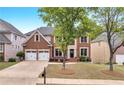Charming two-story brick home featuring a two-car garage and a well-maintained front yard at 2810 Olde Town Park Dr, Norcross, GA 30071