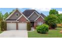 Inviting home with a brick facade, symmetrical design, and lush green landscaping at 3425 Sweet Basil Ln, Loganville, GA 30052
