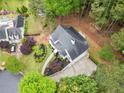 Aerial view of the home with a large driveway and beautiful landscaping in a wooded setting at 1633 Clifton Downs Ct, Kennesaw, GA 30144