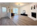 Bright living room boasts a fireplace, modern lighting, and wood-look floors at 2880 Aspen Woods Entry, Doraville, GA 30360