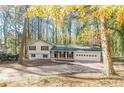 Exterior view showcasing the house with a two car garage, encircled by a lush array of trees, offering both shade and beauty at 4639 Hardwood Rd, Stone Mountain, GA 30083