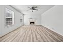 Bright living room with fireplace, ceiling fan, and large windows offering plenty of natural light on wood-look floors at 3362 Alexis Ct, Marietta, GA 30066