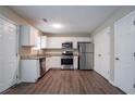 Bright kitchen with white cabinets, stainless steel appliances, granite countertops, and hardwood floors at 4096 Waldrop Hills Dr, Decatur, GA 30034