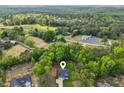 Aerial view of a home, set on a wooded lot, and featuring a well-manicured lawn and convenient attached garage at 7031 Palomino Trl, Winston, GA 30187