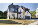 Charming two-story home featuring a mix of painted brick and vertical siding, an attached two-car garage, and well-manicured lawn at 750 Garden Reserve Ln, Alpharetta, GA 30005