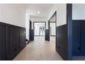 Spacious hallway with wainscoting, light hardwood floors, and open doorways to other rooms at 750 Garden Reserve Ln, Alpharetta, GA 30005