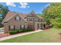 Two-story brick home with red shutters and a well-kept lawn, creating a welcoming curb appeal at 140 Lost Forest Dr, Mcdonough, GA 30252