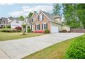 Inviting home with a long drive, two-car garage, brick and vinyl siding, and landscaped yard at 4185 Cami Way, Buford, GA 30519