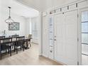 Welcoming foyer featuring wood floors, a white front door with glass panels, and a view into the dining room at 4185 Cami Way, Buford, GA 30519