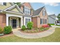 Beautiful entryway to a brick home with a well-maintained lawn, landscaped flower beds, and inviting walkway at 4185 Cami Way, Buford, GA 30519