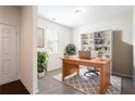 Bright home office with a wooden desk, shelving unit, and natural light from a window at 7747 Rudder Cir, Fairburn, GA 30213