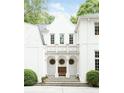 Elegant white stucco home featuring a covered entryway with decorative columns and arched windows at 4705 Paran Nw Vly, Atlanta, GA 30327