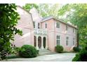 Elegant pink two-story home with a white porch, manicured lawn, and ample parking space at 4705 Paran Nw Vly, Atlanta, GA 30327