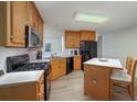 Bright kitchen featuring wooden cabinets, black appliances, and an eat-in area at 332 Red Fox Dr, Canton, GA 30114