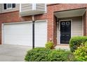 Townhome showcasing a two-car garage, front door, and manicured landscaping at 376 Eagle Tiff Dr, Sugar Hill, GA 30518