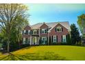 Well-maintained brick home with a lush green lawn and beautiful landscaping at 4015 Dodds Grove Ln, Alpharetta, GA 30009