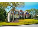 Brick house with black shutters, manicured lawn, and mature trees at 4015 Dodds Grove Ln, Alpharetta, GA 30009