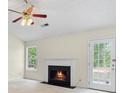 Inviting living room featuring a cozy fireplace, bright windows, and a ceiling fan at 1095 Athena Ct, Acworth, GA 30101