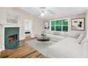 Bright living room featuring fireplace with green marble surround and large window with view to wooded yard at 2539 Lakeside Dr, Villa Rica, GA 30180