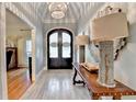 Grand foyer with a decorative chandelier, wood floors, and an elegant entry door at 5475 Trowbridge Dr, Dunwoody, GA 30338