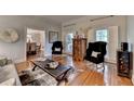 Bright living area with wood floors, black accent chairs, and view into the dining room at 5475 Trowbridge Dr, Dunwoody, GA 30338