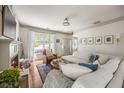 Bright living room with a fireplace, hardwood floors, comfortable seating, and large windows allowing plenty of light at 6000 Hampton Bluff Way, Roswell, GA 30075