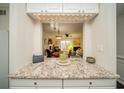 Kitchen view through a pass-through with granite counters, white cabinets, and an open view to the living room at 1261 Lavista Rd # N4, Atlanta, GA 30324