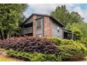 Charming two-story condo boasts a brick facade, wooden balcony, and lush landscaping at 223 Tuxworth Cir, Decatur, GA 30033