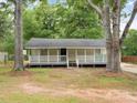 Charming single-story home with a welcoming front porch, framed by mature trees at 5438 Hiram Lithia Springs Rd, Powder Springs, GA 30127