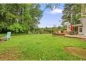 Large backyard with a patio, outdoor seating, and lush green grass, perfect for relaxation at 2801 Holly Oaks Dr, Marietta, GA 30062