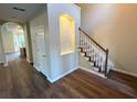 Elegant foyer showcasing hardwood floors, a staircase with white trim, and a built-in arched display niche at 310 Bloomfield Ct, Roswell, GA 30075