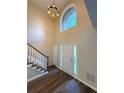 Bright foyer with soaring ceilings, elegant chandelier, and beautiful wood floors with white trim staircase at 310 Bloomfield Ct, Roswell, GA 30075