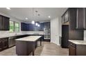 Modern kitchen with dark cabinets, granite countertops, and stainless steel appliances at 245 Brickstone Pkwy, Covington, GA 30016