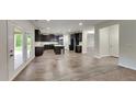 Open-concept kitchen featuring dark cabinets, an island, and seamless flow into living spaces at 245 Brickstone Pkwy, Covington, GA 30016