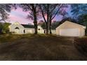 Charming single-story home with a large driveway and well-maintained lawn at dusk at 2490 Turtle Ter, Grayson, GA 30017
