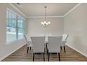 Elegant dining room with a modern chandelier, large windows, and stylish seating for six at 571 Hancock Se Dr, Atlanta, GA 30354