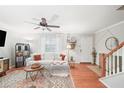Bright living room with hardwood floors, a cozy white sofa, and a ceiling fan for added comfort at 6900 Roswell Rd # J2, Atlanta, GA 30328