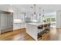 Bright kitchen boasts white cabinets, stainless steel appliances, a marble island with seating, and hardwood floors at 893 E Rock Springs Ne Rd, Atlanta, GA 30306