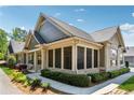 A charming home featuring a screened-in porch with brick accents, and mature landscaping at 1680 Bluestone Dr, Cumming, GA 30041