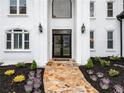 Close-up of the home's entrance featuring a stone pathway, decorative plantings, and an elegant front door at 2321 Edgemere Lake Cir, Marietta, GA 30062