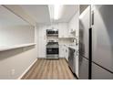 Modern kitchen features stainless steel appliances, white cabinets, and a breakfast bar at 2965 Pharr Court South Nw # 718, Atlanta, GA 30305