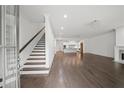 Bright living area with hardwood floors, staircase, open to kitchen, and abundant natural light at 130 Forrest Aly, Roswell, GA 30075