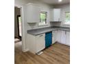 Bright kitchen features white cabinets, granite countertops, new appliances, and modern wood grain flooring at 3080 Hogan Sw Rd, Atlanta, GA 30331