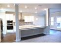 Open-concept kitchen features a large island, stainless steel appliances, and modern lighting at 505 Brown Dove Ln, Grayson, GA 30017