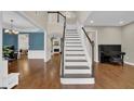 Grand foyer featuring a staircase, hardwood floors, and elegant trim work leading to living areas at 5155 Amberden Hall Dr, Suwanee, GA 30024