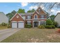 Attractive brick home with manicured lawn, symmetrical design, and inviting curb appeal at 5155 Amberden Hall Dr, Suwanee, GA 30024