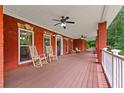 Inviting front porch featuring ceiling fans, rocking chairs, and red brick exterior perfect for relaxation at 7180 Westray Rd, Cumming, GA 30028